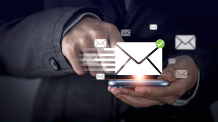 Businessman hand using smartphone sending message with email icon, email marketing concept. Newsletter, contact message used internet. e-commerce letter or mail showing hud.