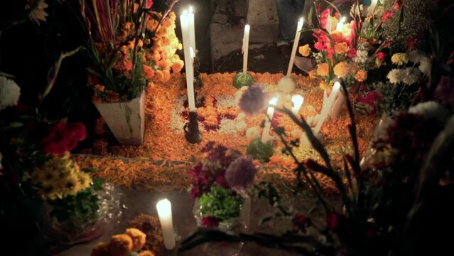 Mexican marigold flowers and candles are decorating a grave during day of the dead celebration