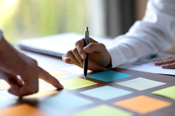 close shot businessman pointing finger at sticky note on table