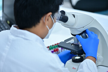 Medical Science Laboratory: Portrait of a scientist looking under a microscope without analyzing a...