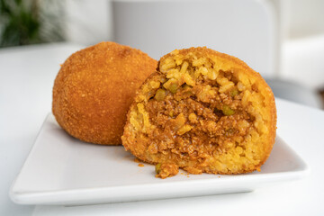Fried rice ball. Arancino Arancina Arancini with ragu on a white plate- Sicilian Street Food