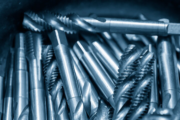 Close up of the pile of used machine tapping tool in light blue scene.