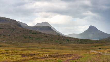 Fototapeta premium Ghostly mountain landscape with clouds and fog over the high peaks in the Highlands, Scotland.