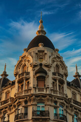 Fototapeta na wymiar An emblematic building in the city of Madrid, Spain, with the soft golden tones of the setting sun and a serene deep, clear blue sky in the background