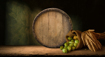 mug of beer, wheat ears, green hops and beer barrel on a wooden background. High quality photo