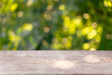 Empty rustic wooden texture of old wood table top, blur against green park with defocused sunlight,...