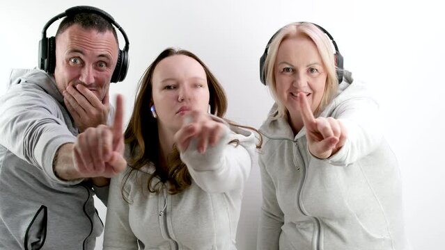 man and two women teenage girl doing negative Swing with index finger No don't do it look into the frame extending hand with finger forward headphones tracksuits. white background