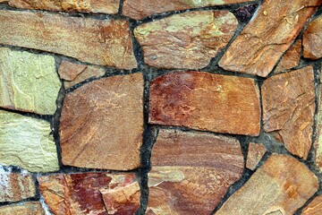 Background, texture wall lined with natural stone in brown shades