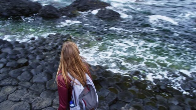 Giant's causeway Ireland with woman walking down to ocean