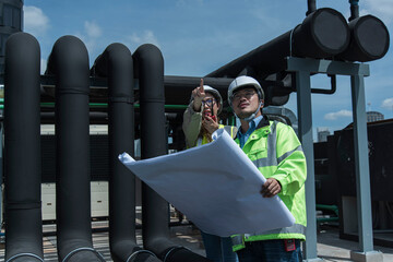 Engineer and team examining the air conditioning cooling system of a huge building or industrial...