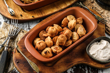 Crunchy fried dumplings with sauce in wooden background, beer snacks