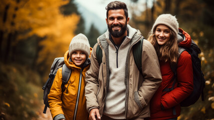 A happy family enjoys a hike through colorful autumn leaves background with empty space for text 