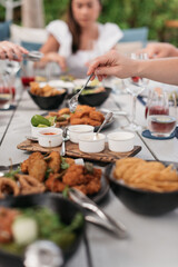group of people enjoying a meal outdoors on a picnic table
