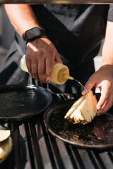 chef preparing pineapple on a grill outside