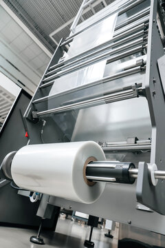vertical bagger reelholder and film unwinding system processing of Packaging equipment on packaging machine in industrial factory. Packing food in production line. Plastic waste