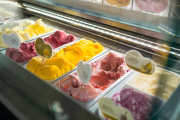 Display window in a store or ice cream parlour of assorted ice cream flavors for sale as summer...