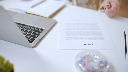 Close-up of woman entrepreneur examining contract on paper in a business office