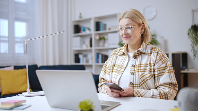 Smiling woman doing shopping online, scanning qr code with a smartphone to pay for a purchase - Powered by Adobe
