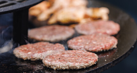 Cook grills steaks and pork ribs open fire. Turns meat over with tongs. Concept Street food