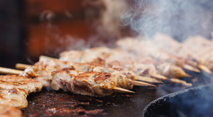 Cook grills chicken kebab steaks open fire. Concept Summer Street food festival
