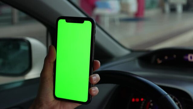 Hand using phone green screen at car 
