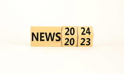 2024 News new year symbol. Businessman turns a wooden cube and changes words News 2023 to News 2024. Beautiful white table white background, copy space. Business 2024 news new year concept.