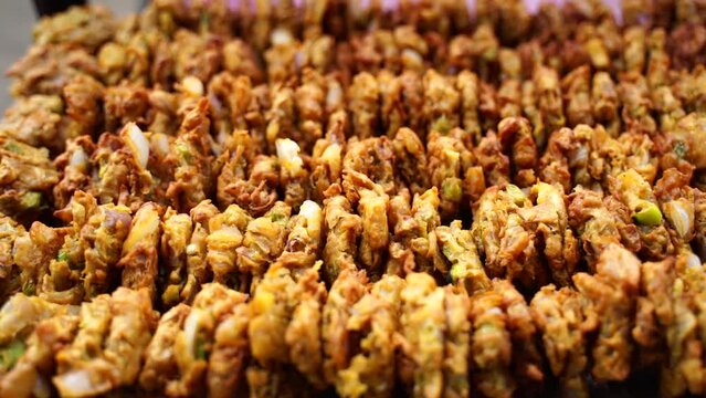 Crunchy and crispy fried pakoda, at Indian food stall close up scene with blur background, pakora and bhujiya.