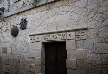 Fifth station of the Cross on the Via Dolorosa, Jerusalem with the inscription "a cross is placed on Simon Cyrenaeus"