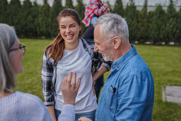 Fototapeta premium Senior woman talking with her grey haired husband and young daughter
