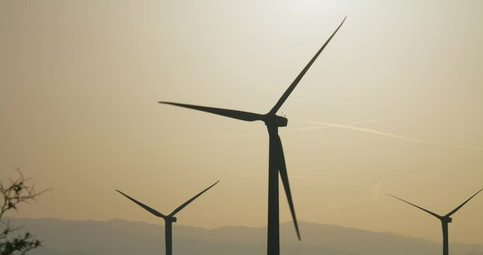 Wind turbines, windmills spinning near Palm Springs San Gorgonio Pass. Mountains in background