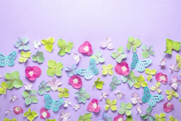 Floral background of colorful hydrangeas and pink paper butterflies. Top view. Festive flat lay and copy space.