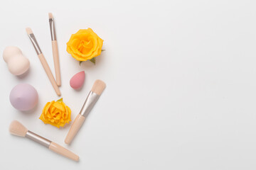 Makeup brushes and sponges on color background, top view