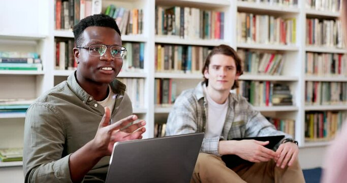 Library, study laptop and student group with conversation and book planning for college project. People, talking and communication for learning and studying for exam with friends for university class