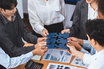 Corporate officer worker collaborate in office, connecting puzzle pieces with report paper on table...