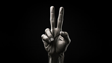 Hand showing peace sign isolated on black background