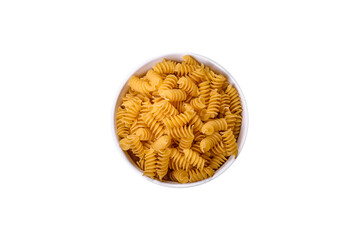 Raw durum wheat pasta in a white bowl on a white background