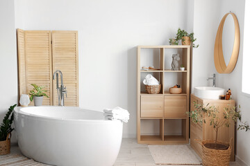 Fototapeta na wymiar Interior of light bathroom with white sink, shelving unit and bathtub