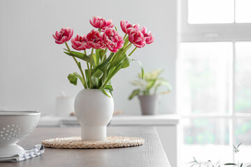 Fototapeta Vase with tulips on table in light kitchen obraz
