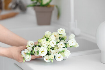 Woman with roses in sink at home, closeup