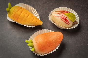 Portuguese marzipan delicacy in the shape of fruit apple, carrot, strawberry. Gourmet sweets from Algarve Portugal on a marble background close-up.