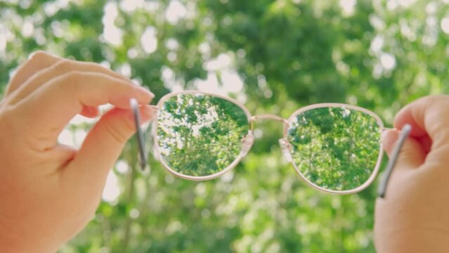 glasses with thin metal frame in female hands, individuals with poor vision adapt lifestyle choices and habits accommodate visual needs, Eyeglass Fashion and Trends