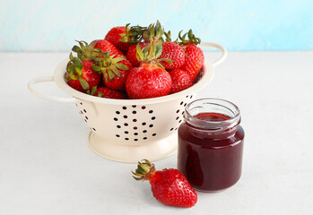 Jar of sweet strawberry jam and fresh berries on table