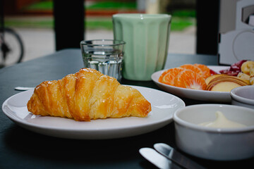 breakfast of croissant, coffee and fruits, healthy and nutritious breakfast