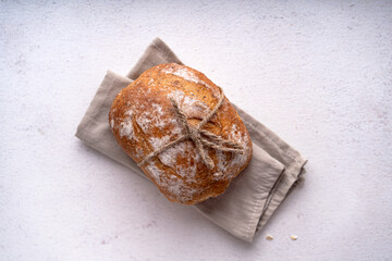 Freshly baked sourdough ciabatta bread with olives and rosemary on a white abstract table. Artisan...
