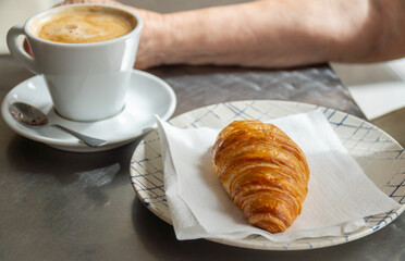 Closeup, a crispy puff pastry bun served on a plate, on the cafeteria table