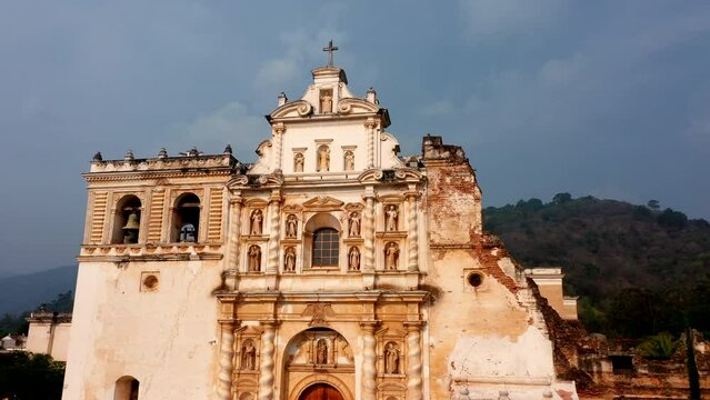 Templo iglesia del Santo Hermano Pedro de Antigua Guatemala fachada vieja antigua con plaza central con muchos &aacute;rboles con calles alrededor con casas y edificios al fondo