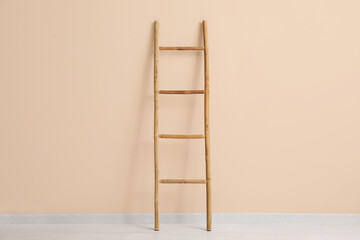 Wooden ladder near beige wall in room