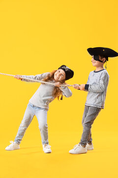 Cute little pirates with rope on yellow background