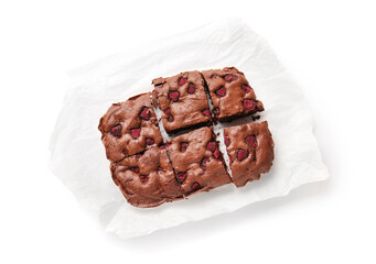 Baking paper with raspberry chocolate brownie on white background