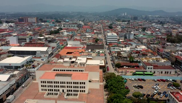 vuelo con drone sobre la ciudad de Guatemala Zona centro con casas y edificios horizonte techos y azoteas con monta&ntilde;as y cerros al fondo calles y caminos